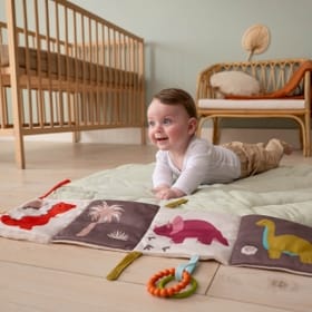 Child playing with Activity Book - Dino on the floor