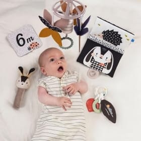 Child Enjoying the Toys in the Black & White Newborn Kit