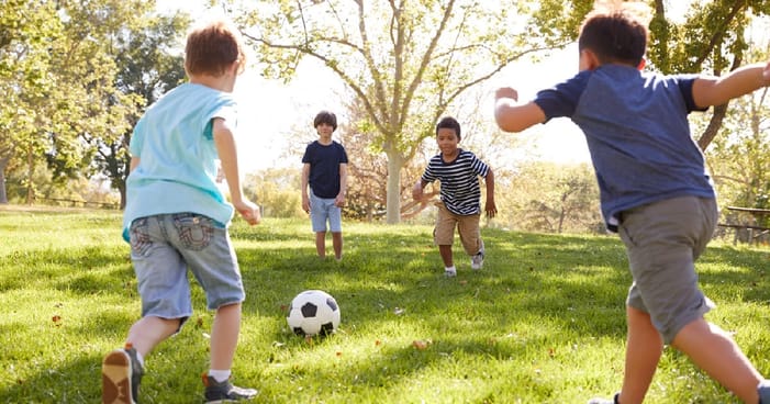 Schoolboys Playing Football Together