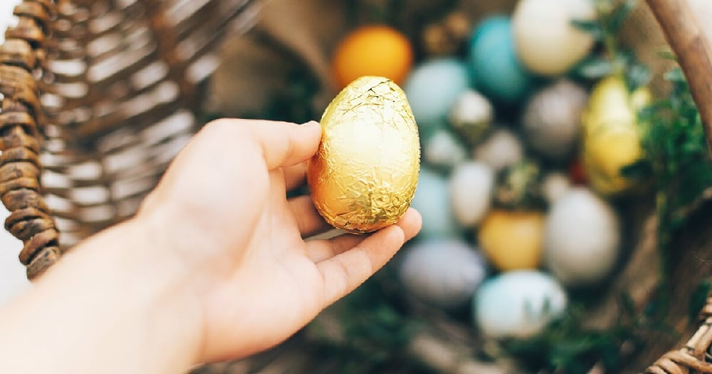 Hand holding golden Easter egg
